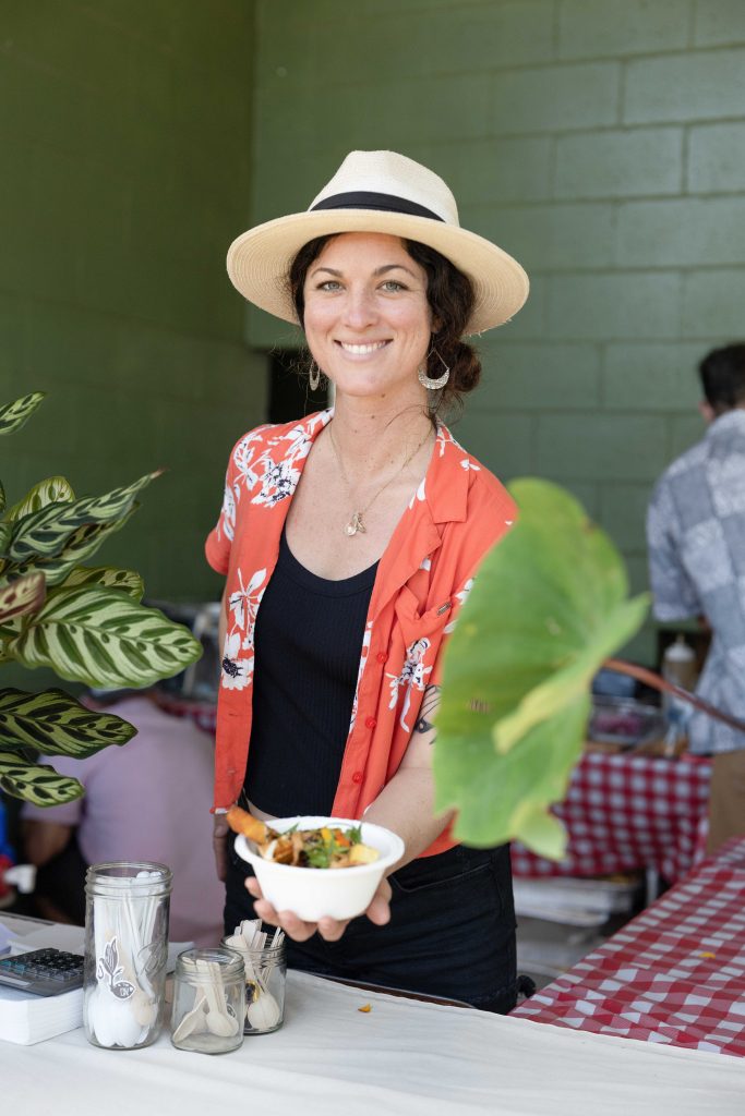 A woman holding out a plate of food